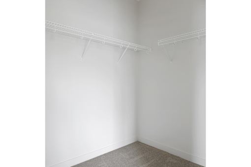 A room with two white shelves on the wall.