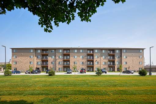 A large apartment building with a grassy area in front.