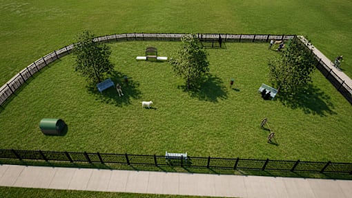A dog park with a black fence and a dog walking on the grass.