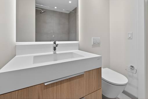 A white sink with a wooden drawer underneath it.