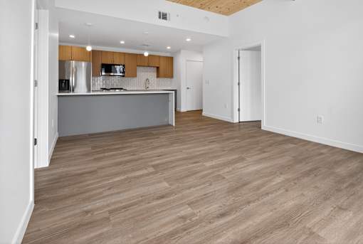 A kitchen with wooden floors and white walls.