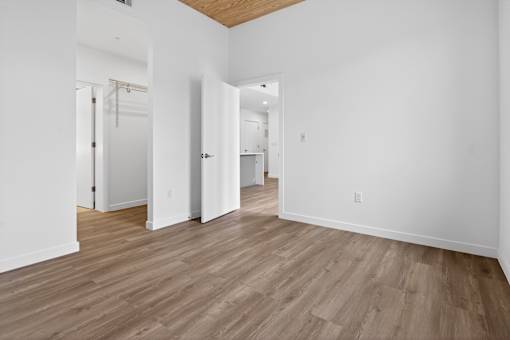 A room with wooden flooring and white walls.