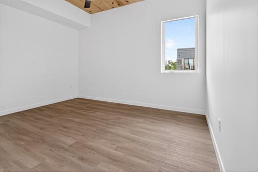 A room with a window showing a building outside.