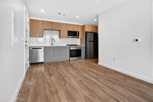 A kitchen with wooden floors and stainless steel appliances.