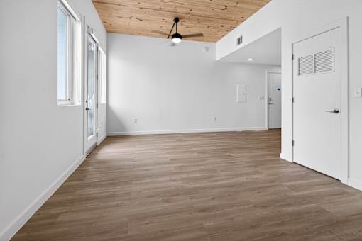 A room with wooden flooring and white walls.