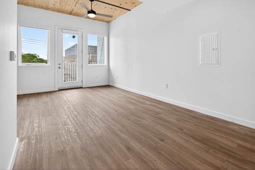 A room with wooden flooring and a ceiling fan.