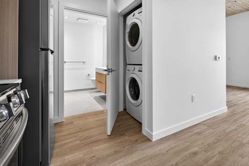 A modern kitchen with a refrigerator and a washing machine built into the wall.