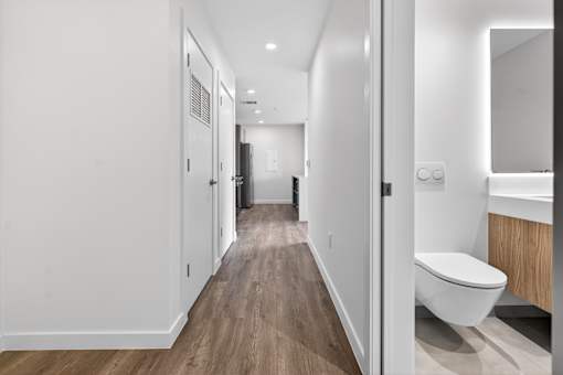 A long, narrow hallway with a toilet visible at the end.