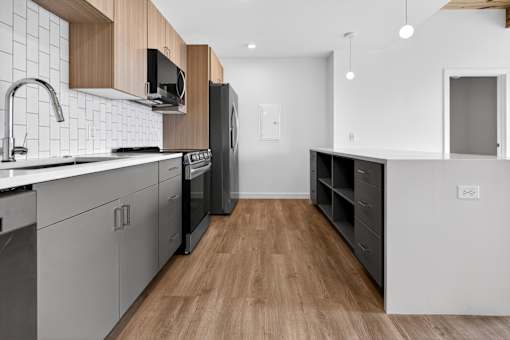 A modern kitchen with wooden floors and white walls.
