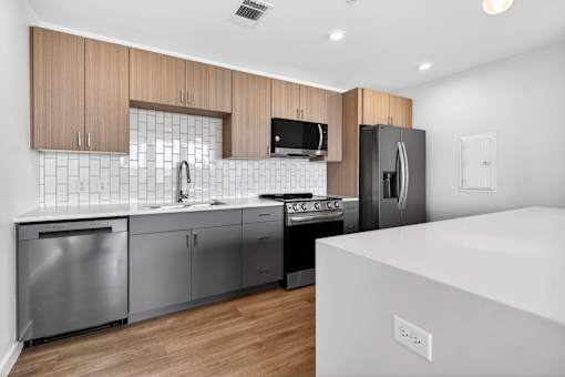 A modern kitchen with stainless steel appliances and wooden cabinets.
