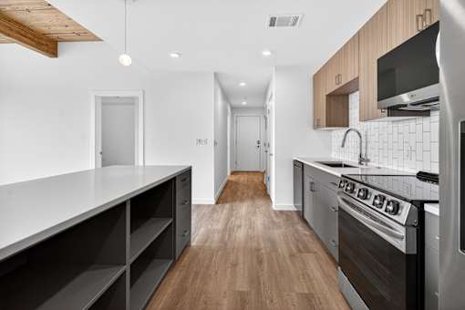 A modern kitchen with a wooden floor and stainless steel appliances.