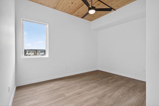 Empty room with a ceiling fan and a window.