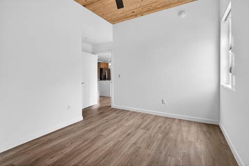 A room with wooden flooring and white walls.