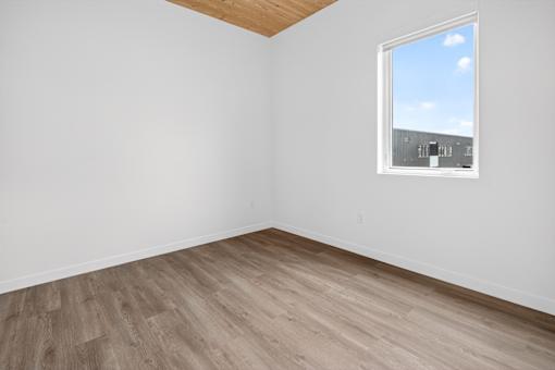 A room with a window and wooden flooring.