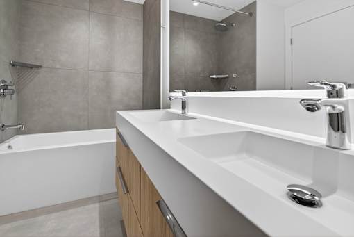 A modern bathroom with a white sink and a white bathtub.