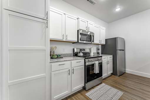 A kitchen with white cabinets and stainless steel appliances.