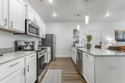 A modern kitchen with white cabinets and stainless steel appliances.