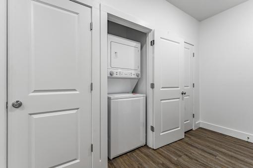 A white door is open to reveal a white oven and microwave.