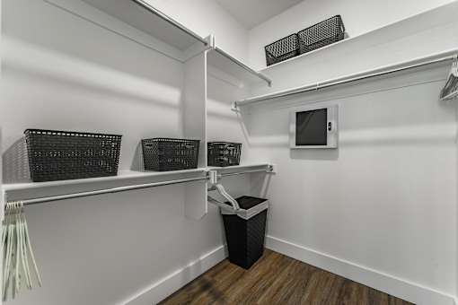 A white closet with a TV and a black trash can.