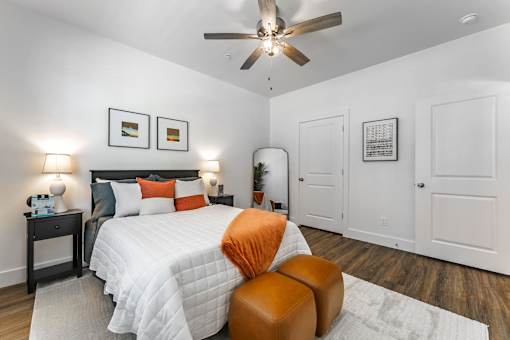 A bedroom with a large bed and a ceiling fan.