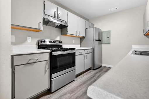 A modern kitchen with stainless steel appliances and white cabinets.