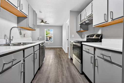 A modern kitchen with white cabinets and a wooden countertop.