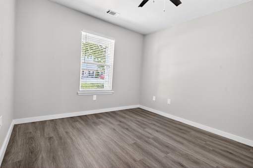 A room with a window and a ceiling fan.