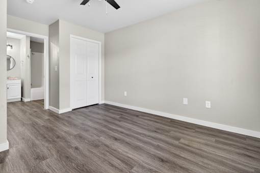 A room with a white door and a ceiling fan.