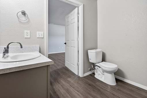 A white toilet sits next to a sink in a bathroom.