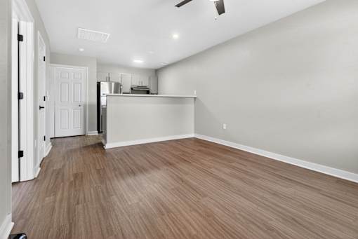 A room with a wooden floor and a ceiling fan.