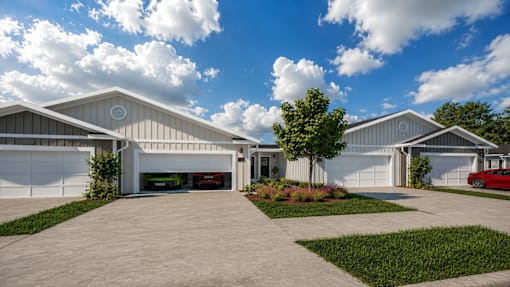A modern house with a red car parked in the driveway.