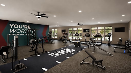 A gym with a variety of equipment and a motivational message on the wall.