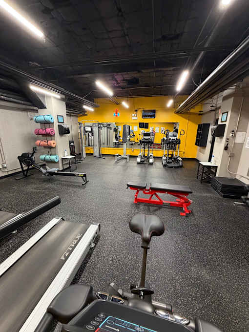 A gym with a treadmill in the foreground.