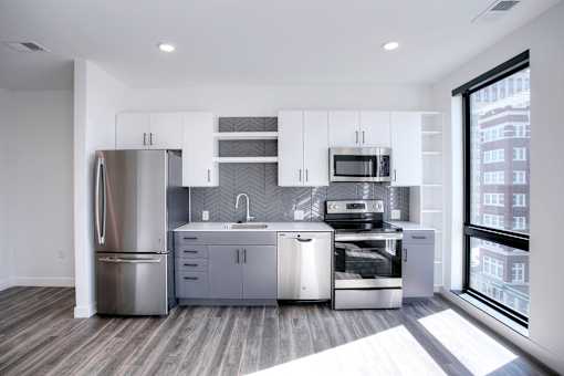 A modern kitchen with stainless steel appliances and wooden flooring.s steel appliances and wooden flooring.
