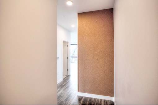 A hallway with a brown wall and a white door.