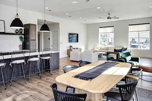 A modern dining room with a wooden table and black chairs.