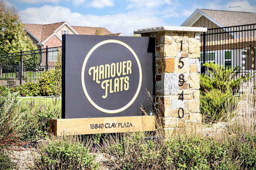 A sign for Handover Flats is displayed in front of a building.