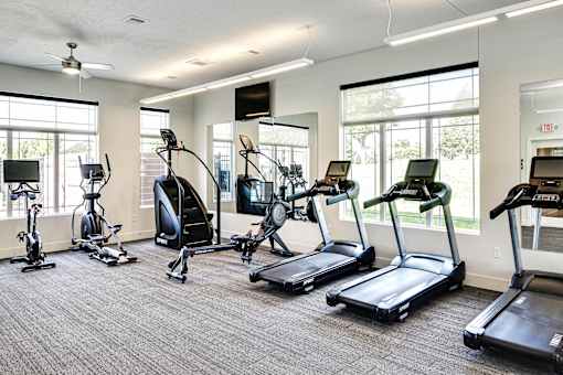A gym with treadmills, elliptical machines, and stationary bikes.