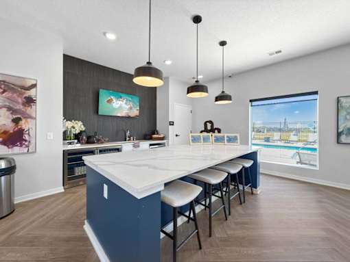 A kitchen with a long island and bar stools.