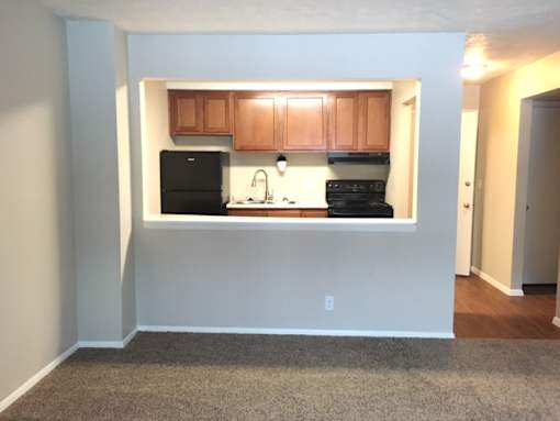 A kitchen with wooden cabinets and black appliances.
