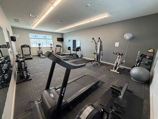 A gym with treadmills, elliptical machines, and other exercise equipment.