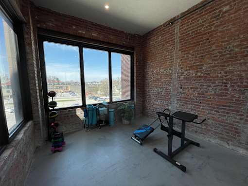 A room with a brick wall and a large window.