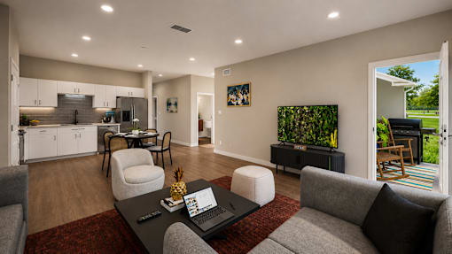 A modern living room with a grey couch, a black coffee table, and a red rug.
