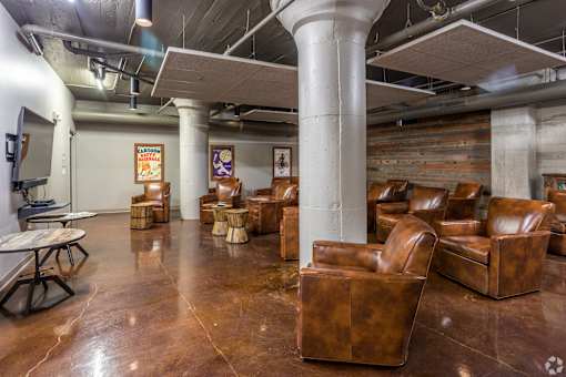 A room with brown leather chairs and a wooden wall.