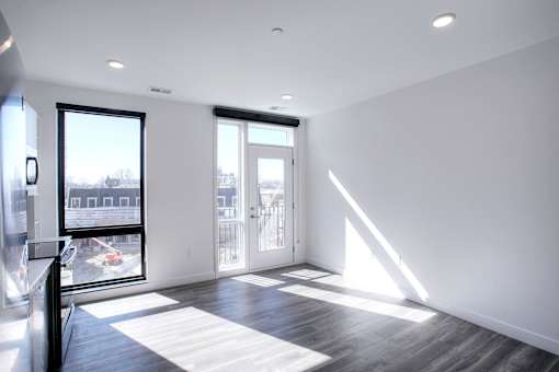 A room with a large window and sliding glass doors.