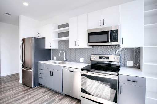 A modern kitchen with stainless steel appliances and white cabinets.