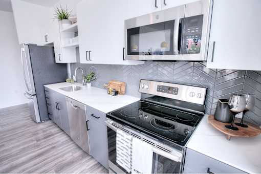 A modern kitchen with stainless steel appliances and white cabinetry.