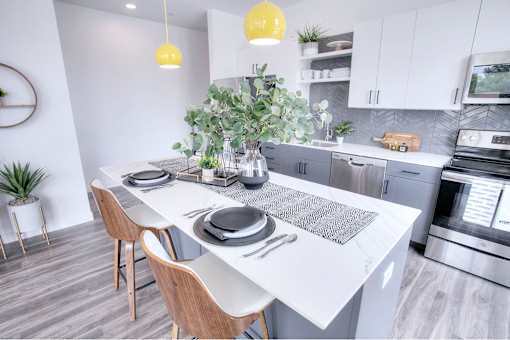 A modern kitchen with a dining table and chairs.