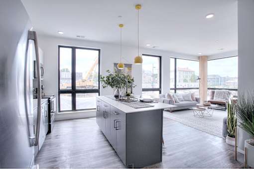 A modern kitchen with a large island and a view of the city.