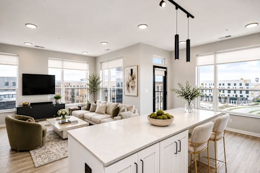 A modern kitchen with a large island and a view of the city.